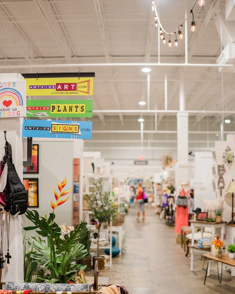 Vendor aisle and hanging shop signs inside Painted Tree